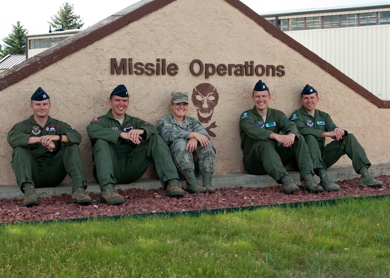 From the left, Capt. Daniel Cook, 90th Operations Support Squadron; Maj. Thomas Perry, 320th Missile Squadron; Staff Sgt. Jennifer Cornett, 321st Missile Squadron; along with Capts. Bennett Johnson and Joshua Wenta, 321st MS, sit in front of the 90th Operations Group’s sign, July 15, 2015. These Airmen rescued five people in the previous month while on a TDY in Florida. (U.S. Air Force photo by Airman 1st Class Malcolm Mayfield) 