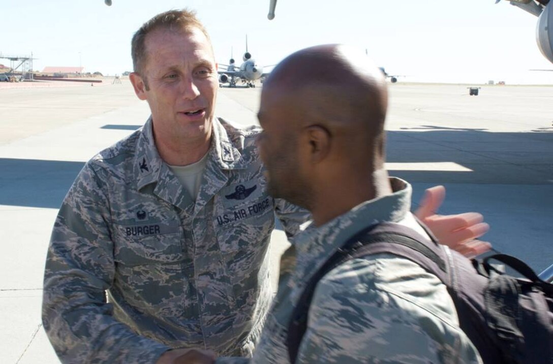 TRAVIS AIR FORCE BASE, Calif. -- Col. Matthew Burger, 349th Air Mobility Wing commander, greets redeploying Airmen at Travis Air Force Base, Calif., July 25, 2015. With loved ones and squadron members waiting, more than 20 members of the wing redeployed after two-to-six months in Southwest Asia. The Airmen deployed in support of aerial refueling operations throughout the region. (U.S. Air Force photo/2nd Lt. Stephen J. Collier) 