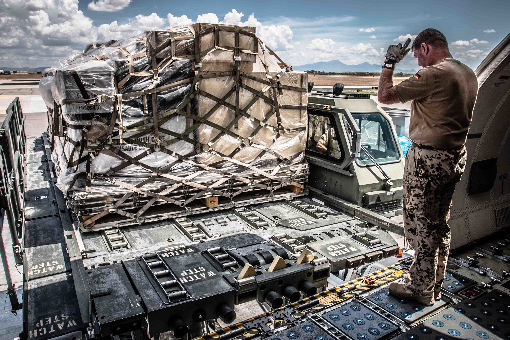 A member of the E-3A Component helps load the cargo jet with recovered spare parts. (Photo by Capt. A. Bongers)