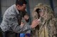 Combat weapons instructor, Senior Airman Cory Irwin from the 37th Training Squadron, helps Raphael Webb don a Ghillie suit, at the weapons display at Joint Base San Antonio-Lackland’s Operation Junior Expeditionary Team on July 31, 2015. The children also got to climb aboard a Humvee and tour a C-5A Galaxy aircraft. (U.S. Air Force photo/Tech. Sgt. Carlos J. Trevino)