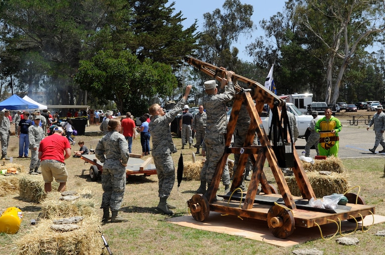 Members of the 30th Operations Support Squadron prepare to launch a cow pie from a trebuchet during the 27th annual Texas Blowout event, July 31, 2015, Vandenberg Air Force Base, Calif. The family friendly event featured a barbeque, car show, children’s games and other activities that encouraged base members to relax and build camaraderie, all in preparation for Operation Kids Christmas – an annual event which supports hundreds of underprivileged children from surrounding communities. (U.S. Air Force photo by Senior Airman Shane Phipps/Released)