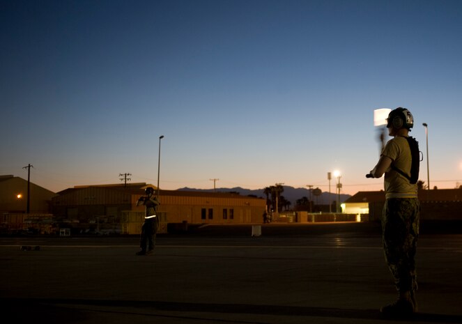 U.S. Navy Petty Officer 2nd Class Scott Flaminio, a plane captain assigned to Electronic Attack Squadron 138, Naval Air Station Whidbey Island, Wash., directs an EA-18G Growler during Red Flag 15-3 at Nellis Air Force Base, Nev., July 28, 2015. Red Flag provides realistic combat training in a contested, degraded and operationally-limited environment, which provides aircrews with real-time war scenarios and helps ground crews test and improve their operational readiness. (U.S. Air Force photo by Airman 1st Class Rachel Loftis)      