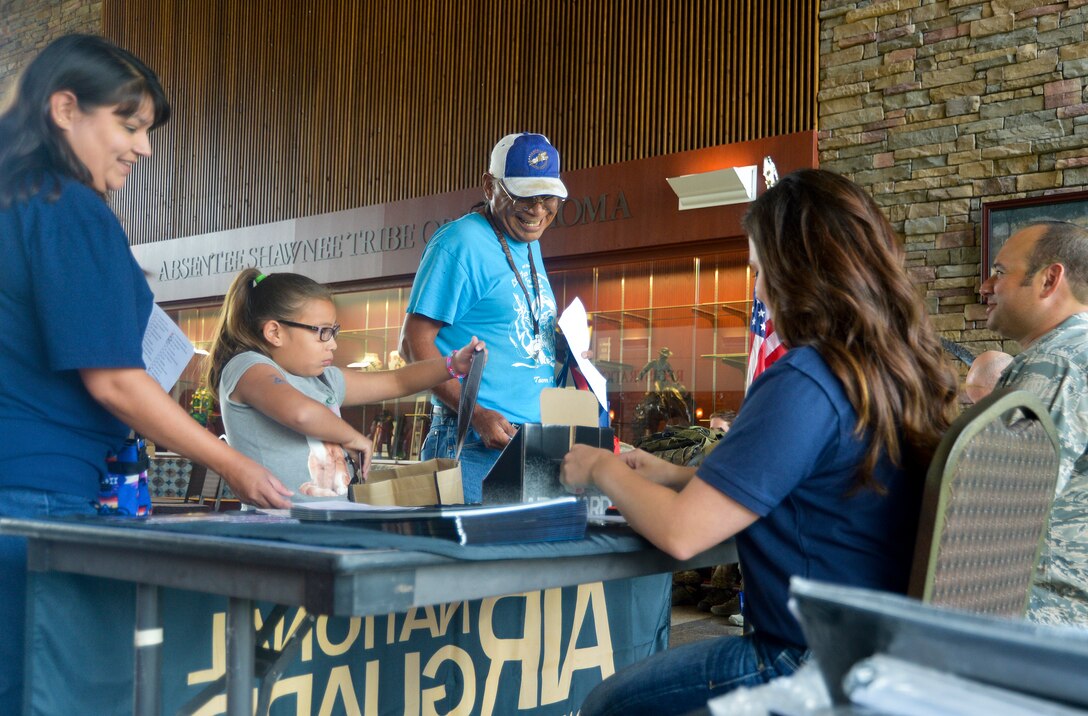 Joe and Twyla Blanchard, with their daughter Erika, visit with members of the Oklahoma Air National Guard during a health fair for the Absentee Shawnee Tribe in Norman, Okla., July 31, 2015. Members from the 137th Medical Group, Air National Guard Recruiting and the 146th Air Support Operations Squadron represented the Air National Guard during the annual health fair by demonstrating life saving techniques and providing recruiting information to the Absentee Shawnee Tribe community. (U.S. Air National Guard photo by Tech Sgt. Trisha Shields/Released)