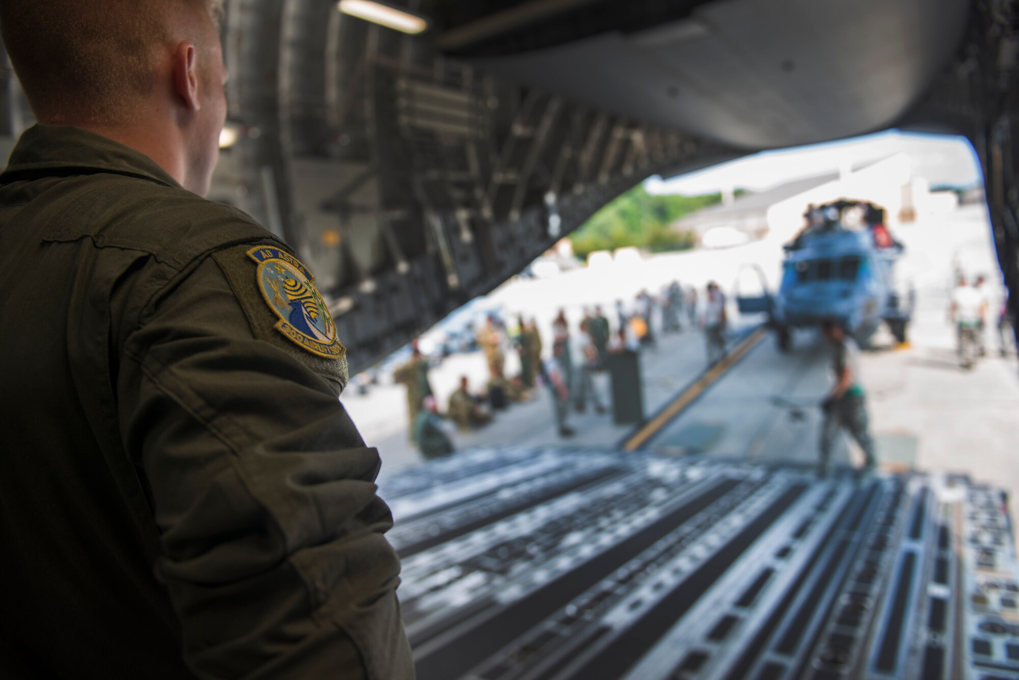 U.S. Air Force Airman 1st Class James Noble, 300th Airlift Squadron loadmaster, guides members of the 41st Helicopter Maintenance Unit as they load an HH-60G Pave Hawk onto a C-17 Globemaster III during rapid-on, rapid-off training July 30, 2015, at Moody Air Force Base, Ga. The 315th Airlift Wing at Charleston AFB, S.C., supports Moody’s rescue mission through transportation of these aircraft. (U.S. Air Force photo by Airman 1st Class Dillian Bamman/Released)