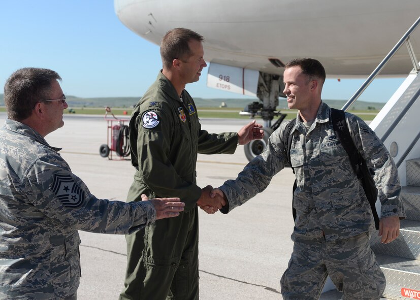 Col. Ty Neuman, 28th Bomb Wing vice commander, and Chief Master Sgt. Kevin Peterson, 28th Bomb Wing command chief, welcome back Airman 1st Class Will, 34th Aircraft Maintenance Unit crew chief, at Ellsworth Air Force Base, S.D., July 30, 2015. More than 350 Airmen returned from Southwest Asia where they served in support of Operation Freedom’s Sentinel and Operation Inherent Resolve. (U.S. Air Force photo by Senior Airman Anania Tekurio/Released)