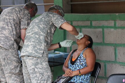 Sgt. Kyron Brown (center), assists Col. Bruce Bikson (far left), General Dentist from JTF-Bravo’s Medical Element,  as they perform a dental extraction during a two -day Medical Readiness Training Exercise in the Ramon Ortega School of Las Liconas, Comayagua, July 29, 2015. During these exercises, the people from nearby communities can receive much -needed free dental care, preventive medical care, vitamins and other medication, as well as wellness checkups.  (U.S. Army photo by Maria José Pinel) 