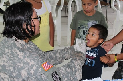 Sgt. Mary King, a preventive medicine specialist from JTF-Bravo’s Medical Element, provides a four- year -old boy with antiparasitic medication during a two -day Medical Readiness Training Exercise in the village of Las Liconas, Comayagua, July 29, 2015.  These exercises allow US service members to engage with the local community and partner with the Honduran Ministry of Health, while validating their ability to provide services in the field. (U.S. Army photo by Maria José Pinel)