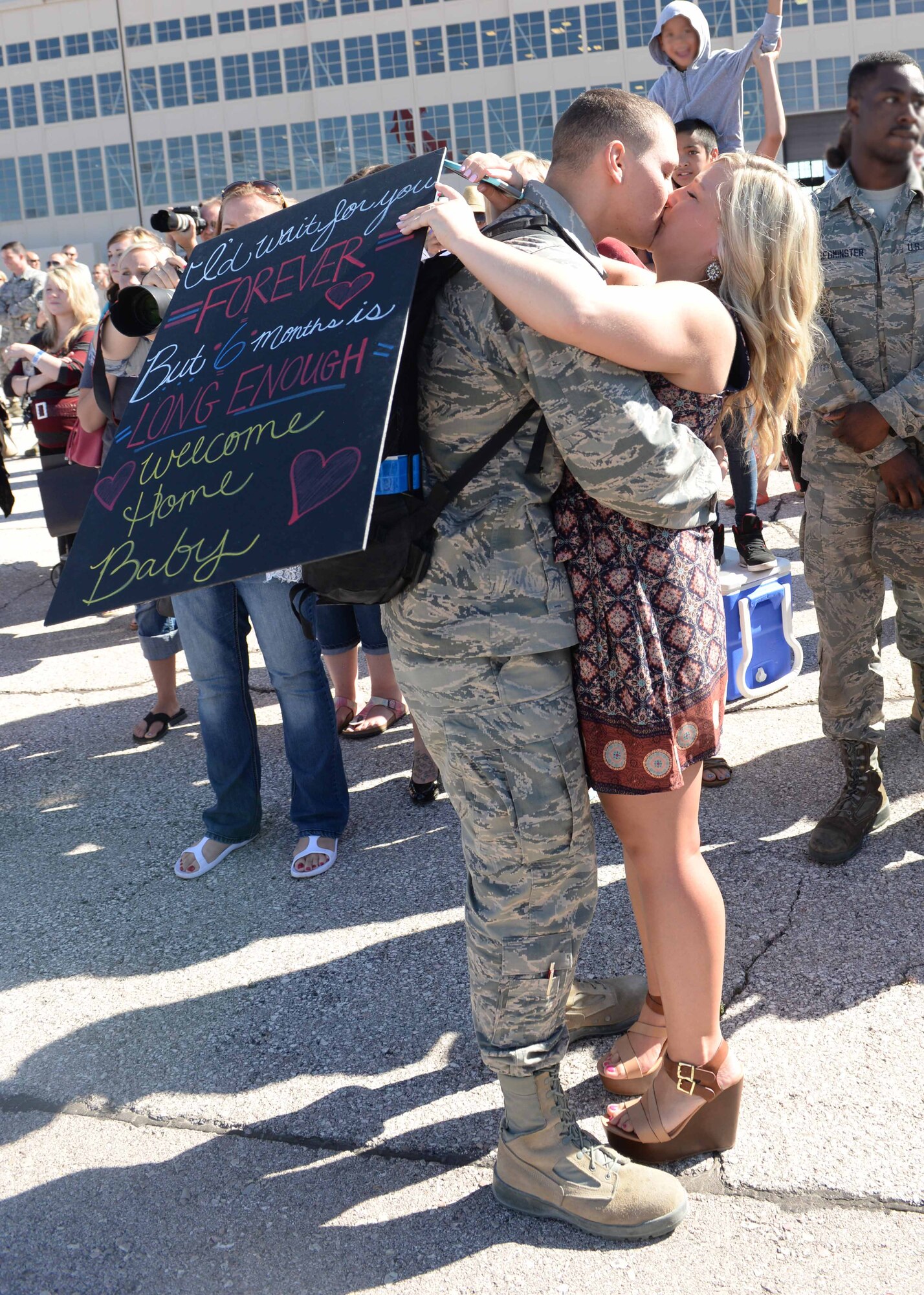 Senior Airman Madison, 28th Munitions Squadron conventional maintenance crew member, kisses his spouse, Caitlan, upon his return from deployment, Ellsworth Air Force Base, S.D., July 30, 2015. Madison was among the approximately 350 Airmen who returned home after supporting operations in Southwest Asia. (U.S. Air Force photo by Senior Airman Rebecca Imwalle/ Released)