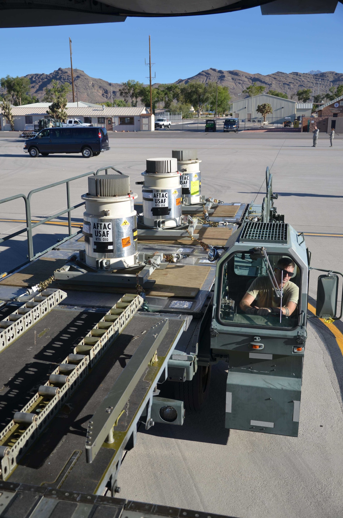 Three radioisotope thermoelectric generators belonging to the Air Force Technical Applications Center, Patrick AFB, Fla., are downloaded from an Air Force C-17 Globemaster III onto a 25K loader at Creech AFB, Nevada, July 24, 2015 in preparation for transport to the Nevada National Security Site.  The RTGs, which contain nuclear material, were transported from Burnt Mountain, Alaska after being decommissioned as a power source.  By regulation, radioactive material determined to be excess must be moved to a facility with a mission, capability and authorization to support long-term storage or recycling of the material. (U.S. Air Force photo by Susan A. Romano)