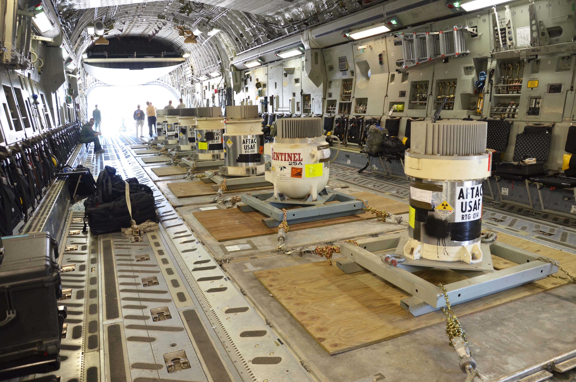 Seven radioisotope thermoelectric generators are lined up aboard an Air Force C-17 Globemaster III after being removed from Burnt Mountain, Alaska, and transported to Creech AFB, Nevada, July 24, 2015, in preparation for permanent disposal at the Nevada National Security Site.  The RTGs, which contain nuclear material, were once used as a power source for the Air Force Technical Applications Center's seismic array, which monitors seismic activity in the region. The RTGs were replaced with a hybrid power source.  (U.S. Air Force photo by Susan A. Romano)