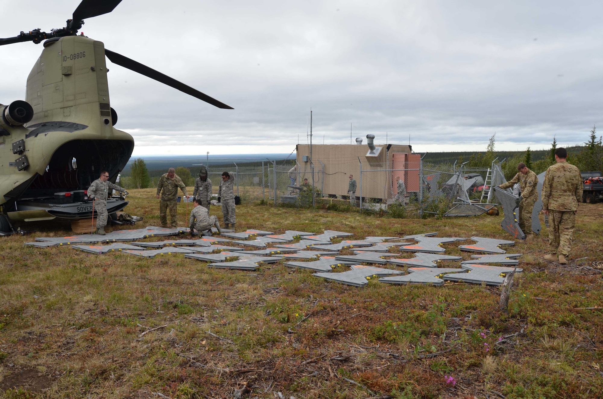 Airmen from the Air Force Technical Applications Center's Detachment 460 at Eielson AFB and Soldiers from B Company, 1-52 Aviation Brigade at Ft. Wainwright – both units near Fairbanks, Alaska – painstakingly lay several yards of modular interlocking surfacing July 17, 2015, to help shore up the ground as the crews transferred two radioisotope thermoelectric generators, or RTGs, via forklift to an awaiting CH-47 Chinook.  The RTGs, which contain nuclear material, were originally used as a power source, but were deemed excess when a hybrid power source was developed to operate AFTAC's seismic array. (U.S. Air Force photo by Susan A. Romano)
