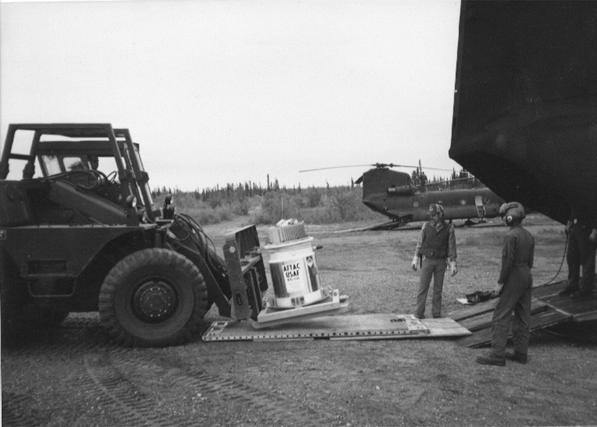The original radioisotope thermoelectric generator is downloaded from a helicopter at Burnt Mountain, Alaska, 60 miles north of the Arctic Circle, circa 1973.  The generator was once used as a power source for seismometers used by the Air Force Technical Applications Center based at Patrick AFB, Fla.  AFTAC's mission is to verify compliance with nuclear test ban treaties.  (U.S. Air Force photo)