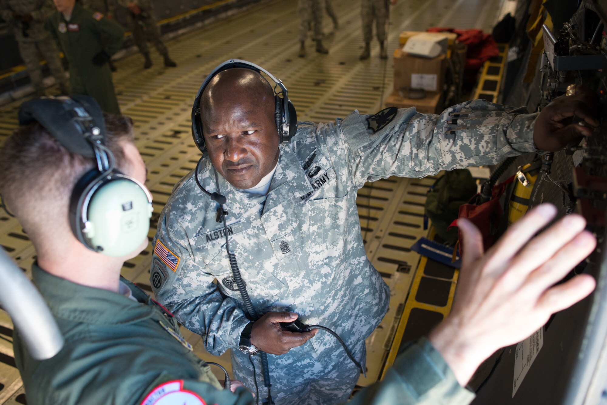Staff Sgt. Matthew Dolan, 22nd Airlift Squadron load master, instructs Alston on how to marshal vehicles from the cargo area of a C-5M Super Galaxy at Travis Air Force Base, Calif. (U.S. Air Force photo by Ken Wright)