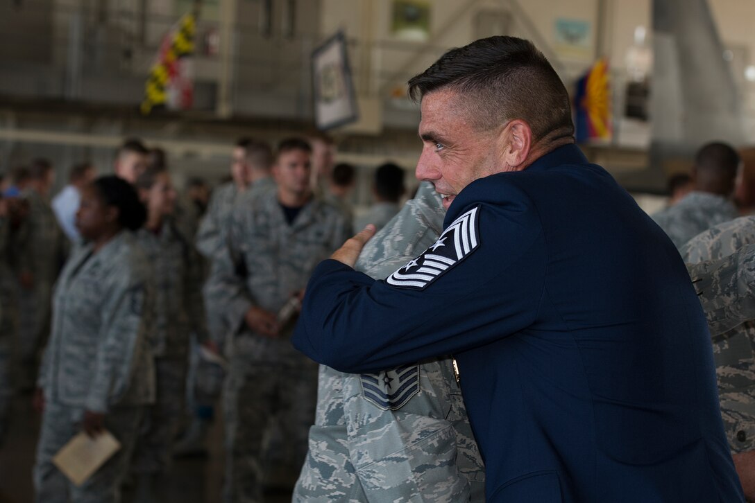 U.S. Air Force Chief Master Sgt. Charles Burgess, retired 82nd Training Wing command chief, hugs his friends and colleagues after his retirement ceremony, July 31, 2015, at Sheppard Air Force Base, Texas. Burgess was known for his passion for taking care of military members and their families. He led various initiatives across the base for quality of life improvements. (U.S. Air Force photo by Senior Airman Kyle Gese/Released)