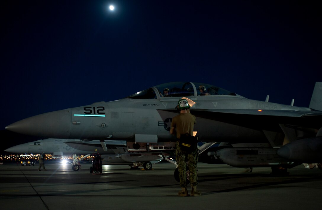 U.S. Navy Petty Officer 3rd Class Ryan Gosch, a plane captain assigned to Electronic Attack Squadron 138, Naval Air Station Whidbey Island, Wash., marshals the aircrew of an EA-18G Growler during Red Flag 15-3 at Nellis Air Force Base, Nev., July 28, 2015. Red Flag provides realistic combat training in a contested, degraded and operationally-limited environment. These stressors provide aircrews with real-time war scenarios and helps ground crews test and improve their operational readiness. (U.S. Air Force photo by Airman 1st Class Mikaley Towle)