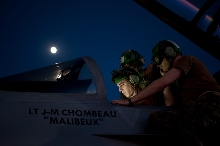 U.S. Navy sailors assigned to Electronic Attack Squadron 138, Naval Air Station Whidbey Island, Wash., perform pre-flight inspections on an EA-18G Growler during Red Flag 15-3 at Nellis Air Force Base, Nev., July 28, 2015. In addition to day-time operations, Red Flag conducts training exercises during the hours of darkness to train for low-visibility environments. (U.S. Air Force photo by Airman 1st Class Mikaley Towle)