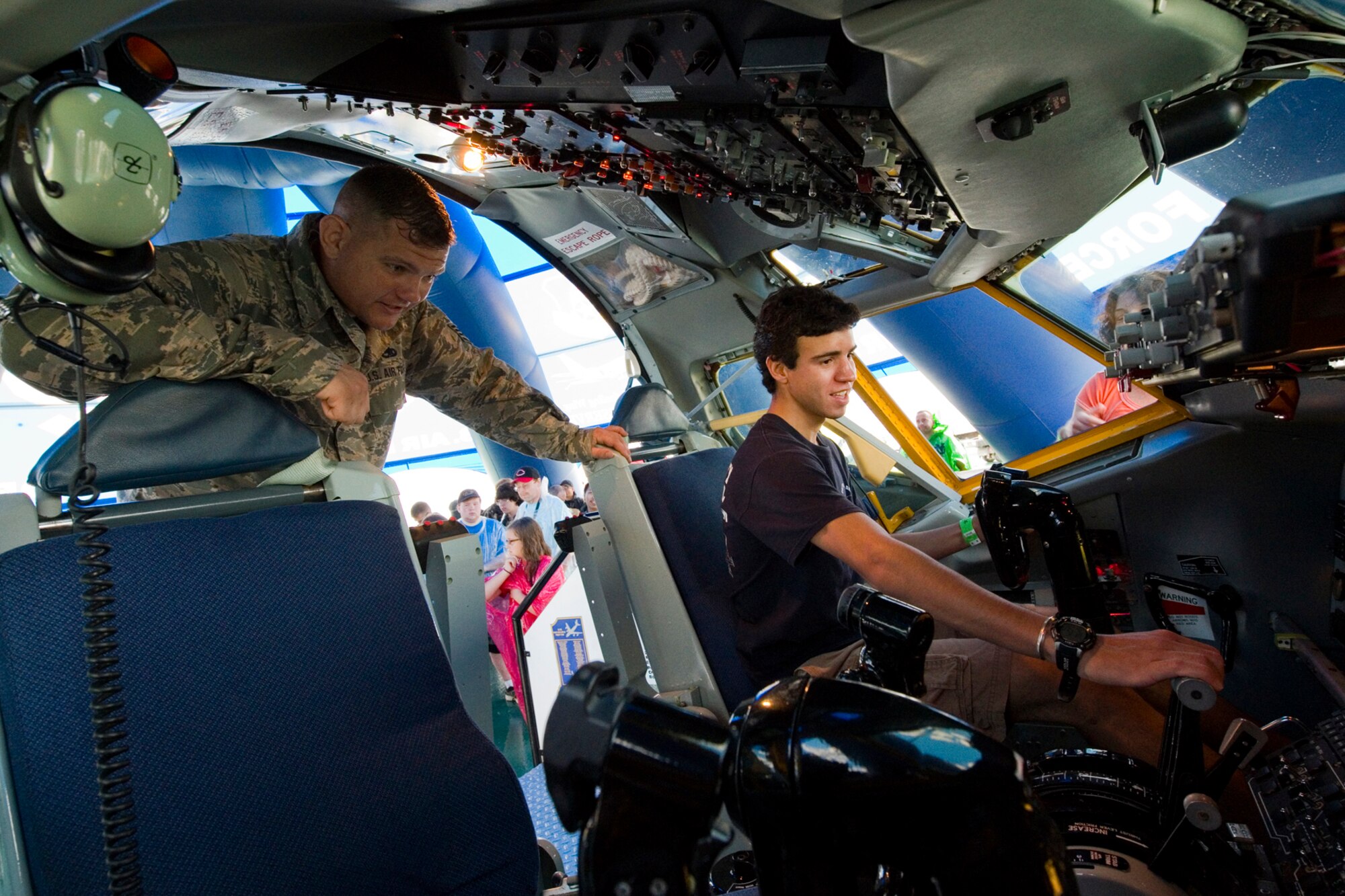 Staff Sgt. Joe Meyer, 434th Aircraft Maintenance Squadron crew chief, explains the controls of a KC-135R Stratotanker interactive flight deck to Grant Harlan at the Dayton Vectron Airshow in Dayton, Ohio, June 20, 2015. During the event, Meyer and seven other Airmen volunteered to setup up and operate the displays while sharing their military knowledge with visitors. (U.S. Air Force photo/Tech. Sgt. Benjamin Mota)