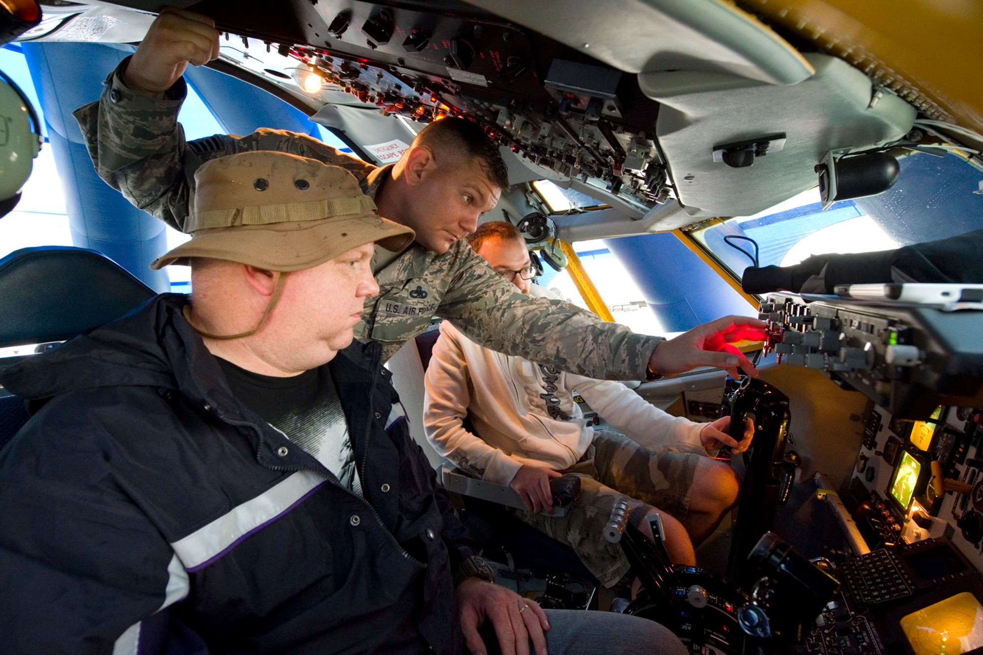 Staff Sgt. Joe Meyer, 434th Aircraft Maintenance Squadron crew chief, explains the controls of a KC-135R Stratotanker interactive flight deck to David Bayne, left, and his son, Zach Bayne, at the Dayton Vectron Airshow in Dayton, Ohio, June 20, 2015. During the event, Meyer and seven other Airmen volunteered to setup up and operate the displays while sharing their military knowledge with visitors. (U.S. Air Force photo/Tech. Sgt. Benjamin Mota)