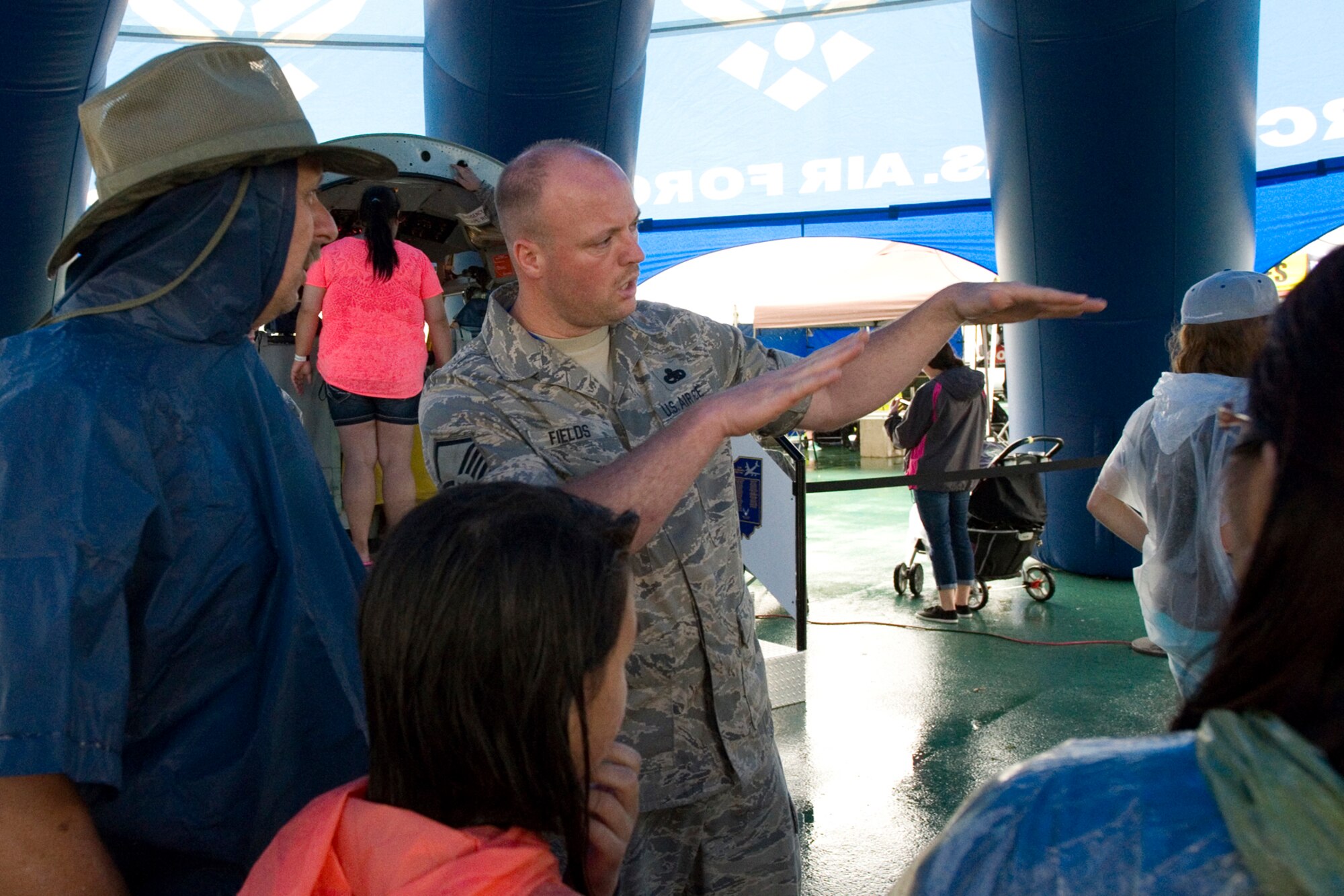Master Sgt. Corey Fields, 434th Maintenance Squadron structural maintenance supervisor, explains aerial refueling to visitors waiting to experience Grissom's interactive flight deck and boom pod displays at the Dayton Vectron Airshow in Dayton, Ohio, June 20, 2015. During the event, Fields and seven other Airmen volunteered to setup up and operate the displays while sharing their military knowledge with visitors. (U.S. Air Force photo/Tech. Sgt. Benjamin Mota)