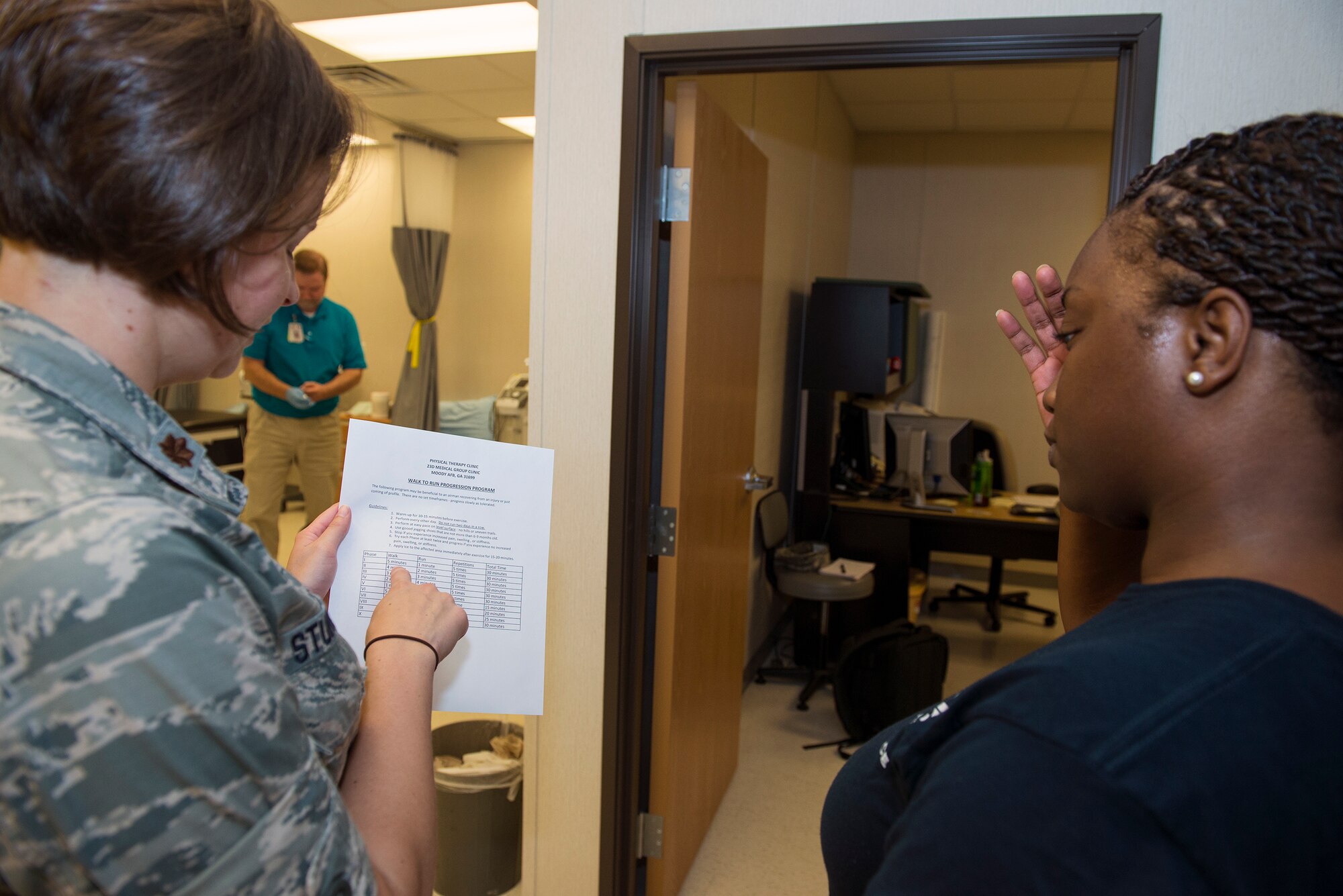 U.S. Air Force Maj. (Dr.) Erin Sturgell (left), 23d Medical Operations Squadron clinical medicine flight commander, explains the guidelines of a walk-to-run progression program to Airman 1st Class Jasmine Barnes, 23d Mission Support Group command section administrator, during an appointment July 28, 2015, at Moody Air Force Base, Ga. The walk- to-run program benefits recovering Airmen from injuries by allowing them to gradually improve on foot mobility with increased workloads in phases. (U.S. Air Force photo by Airman Greg Nash/Released)  