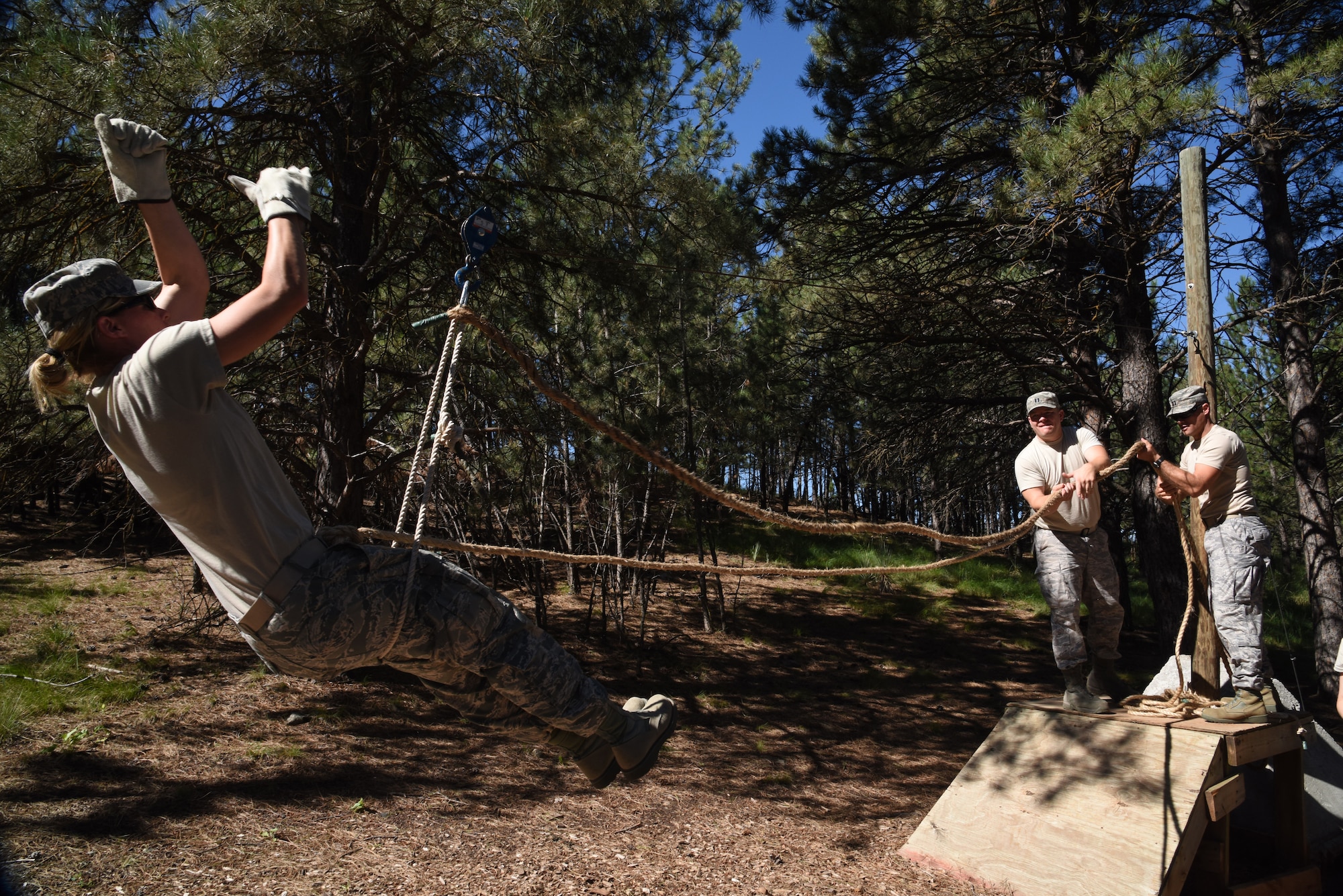 Staff Sgt. Rachel Vanbeek, 114th Medical Group aerospace medical service technician, pulls herself across an overhead wire in order to complete a challenge on the leadership reaction course at Camp Rapid, Rapid City S.D. July 30, 2015.  The Medical Group, along with members of the Security Forces Squadron from the South Dakota Air National Guard took advantage of an opportunity to train alongside the South Dakota Army National Guard during their two week annual training. (National Guard photo by Tech. Sgt. Christopher Stewart/Released)