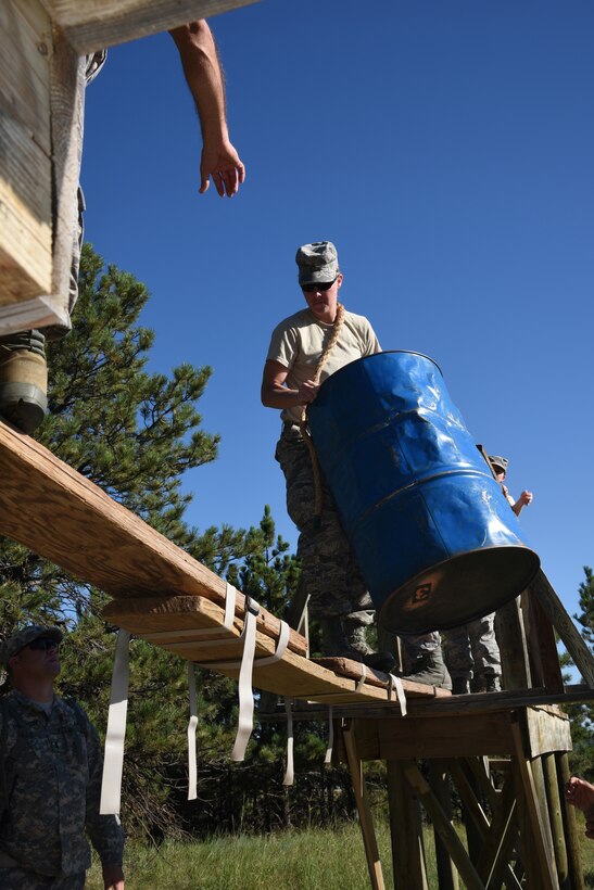 Staff Sgt. Rachel Vanbeek, 114th Medical Group aerospace medical service technician, carries a barrel across a narrow hand constructed bridge at the Leadership Reaction Course at Camp Rapid, Rapid City S.D., July 30, 2015.  The Medical Group, along with the 114th Security Forces Squadron of the South Dakota Air National Guard, took advantage of an opportunity to train alongside the South Dakota Army National Guard during two week annual training.  Never in the history of the National Guard have we been better trained, equipped or more heavily relied upon than we are today. (National Guard photo by Tech. Sgt. Christopher Stewart/Released)