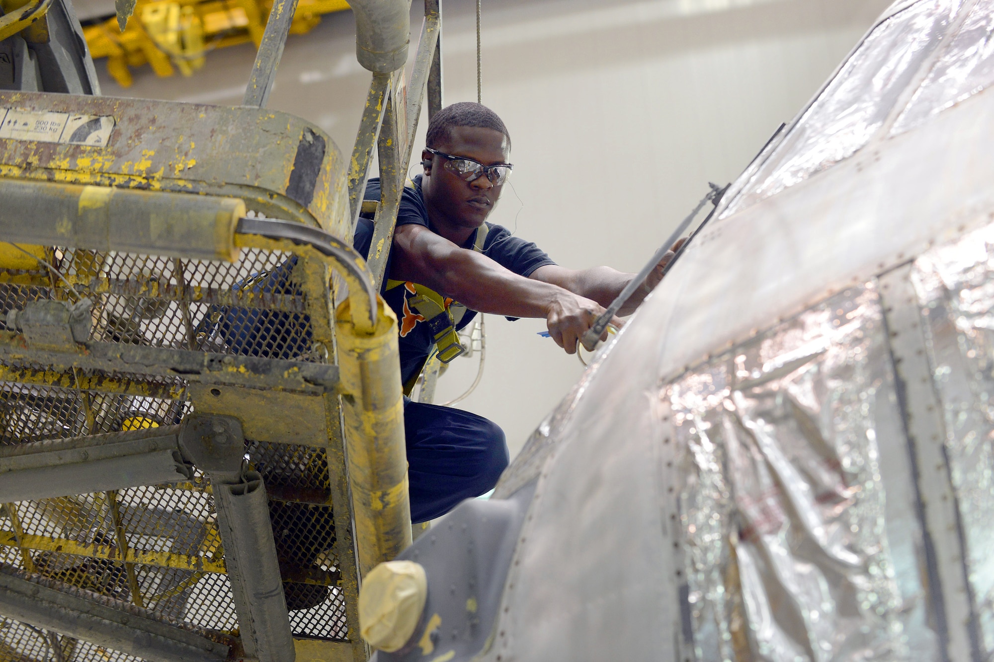 Jarico Jones, 402nd Aircraft Maintenance Squadron aircraft painter, masks the windows of a C-130 in preparation for painting at the Warner Robins Air Logistics Complex July 27, 2015. (U.S. Air Force photo by Tommie Horton)