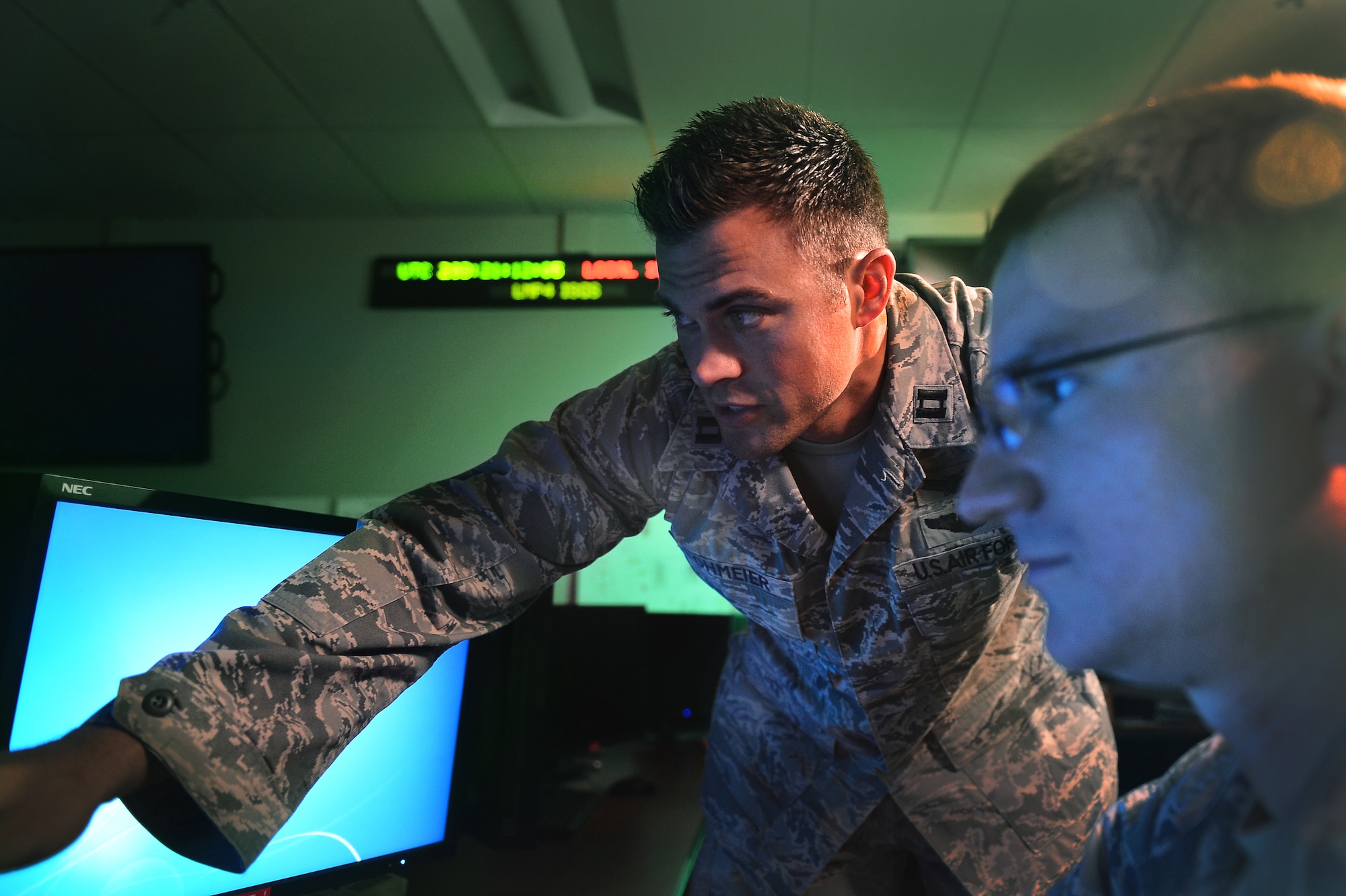 Capt. Matthew Lohmeier, 460th Operations Group Block 10 chief of training, stands in the Standardized Space Trainer July 22, 2015, on Buckley Air Force Base, Colo. The SST is a state-of-the-art training suite designed to emulate the new Block 10 operations floor environment and increase the speed and efficiency with which new space operators learn their mission. (U.S. Air Force photo by Senior Airman Darren Scott/Released)