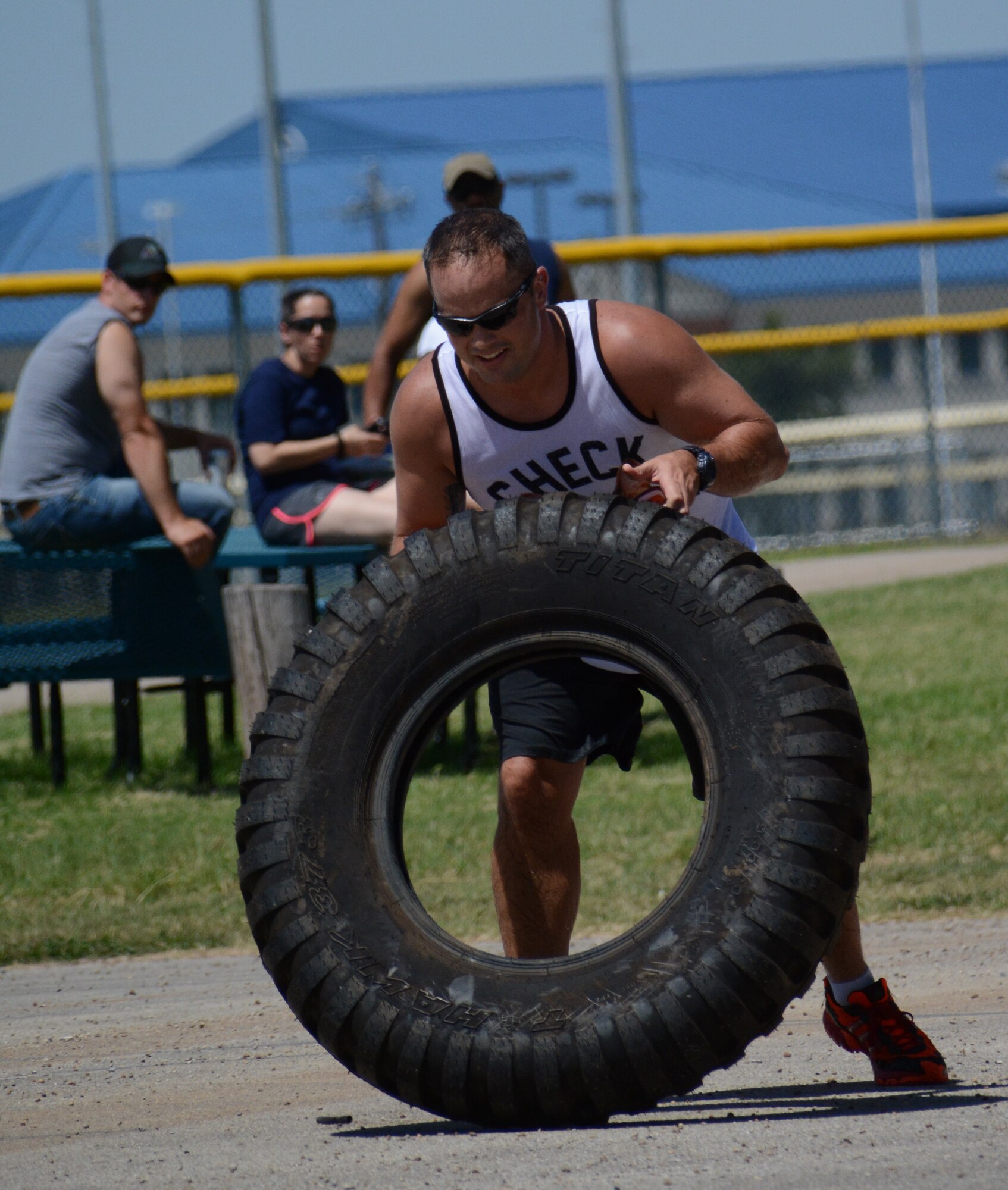 NAVAL AIR STATION FORT WORTH JOINT RESERVE BASE, Texas - 1st Lt. Joel Brown, 301st Security Forces Squadron operations officer, flips a tire July 11 for the second part of the 610 SFS Family Day Challenge at Naval Air Station Fort Worth Joint Reserve Base, Texas. Forty-eight Airmen participated in the challenge and competed in a canoe race, tire flip, litter carry and bat spin. This year the 301 SFS joined the 610 SFS in the annual event. (U.S. Air Force photo by Staff Sgt. Samantha Mathison)