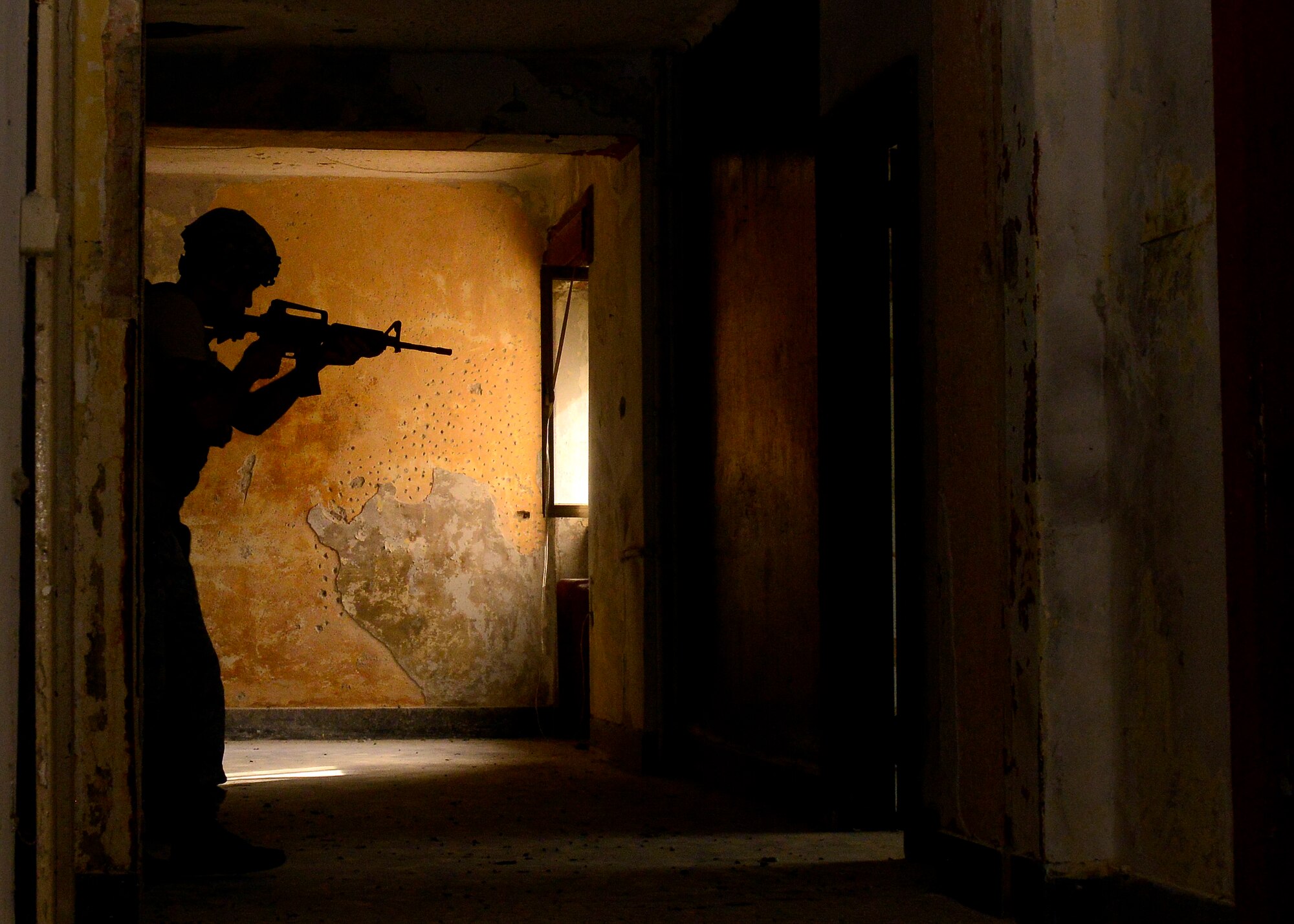A U.S. Air Force defender secures a hallway during security clearing training, July 30, 2015, at Aviano Air Base, Italy. Approximately 20 defenders participated in offensive and defensive tactics to help prepare themselves for real-life scenarios. (U.S. Air Force photo by Airman 1st Class Cary Smith/Released) 