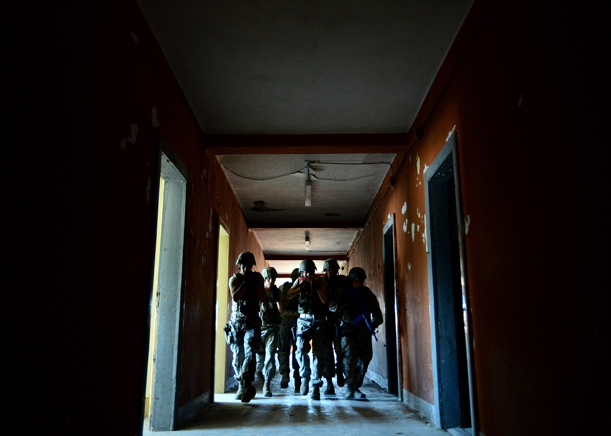 U.S. Air Force Airmen with the 31st Security Forces Squadron clear an abandoned room July 30, 2015, at Aviano Air Base, Italy.  Approximately 20 defenders trained on security breaches, clearing buildings and other defensive and offensive tactics to prepare for real-life situations. (U.S. Air Force photo by Staff Sgt. Evelyn Chavez/Released)