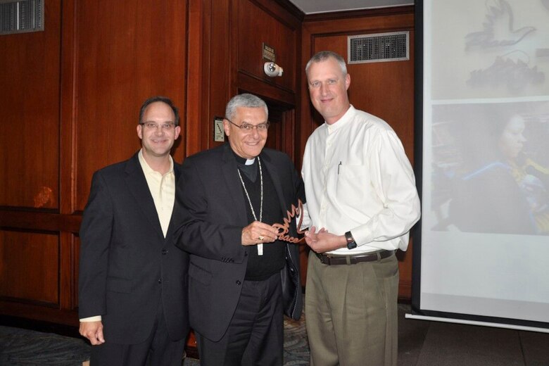 U.S. Air Force Chaplain, Lt. Col. Brian Bohlman and Master Sgt. Charles Williams Chaplain Assistant, give Monsignor Fabio Suescun Mutis, Archbishop for the Colombian Military, a peace dove during a three-day symposium in Bogota, Colombia, July 13-16.  The symposium was an opportunity to share with other Nations ideas on how religion matters to military commanders, service members and their families. 
(Courtesy Photo/Released)