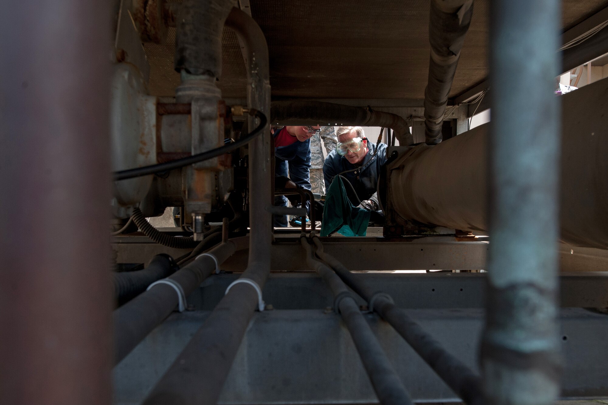 Senior Airman Matthew Long, 8th Civil Engineer Squadron heating, ventilation, air conditioning and refrigeration journeyman, shows Lt. Gen. Terrence O'Shaughnessy, 7th Air Force and Air Component Command U.S. Forces Korea/U.S. Combined Forces commander, how to solder an electronic expansion valve of a chiller at Kunsan Air Base, Republic of Korea, July 31, 2015. During O’Shaughnessy’s two-day visit, he saw first-hand how the Wolf Pack contributes to deterring aggression on the peninsula. (U.S. Air Force photo by Senior Airman Katrina Heikkinen/Released)