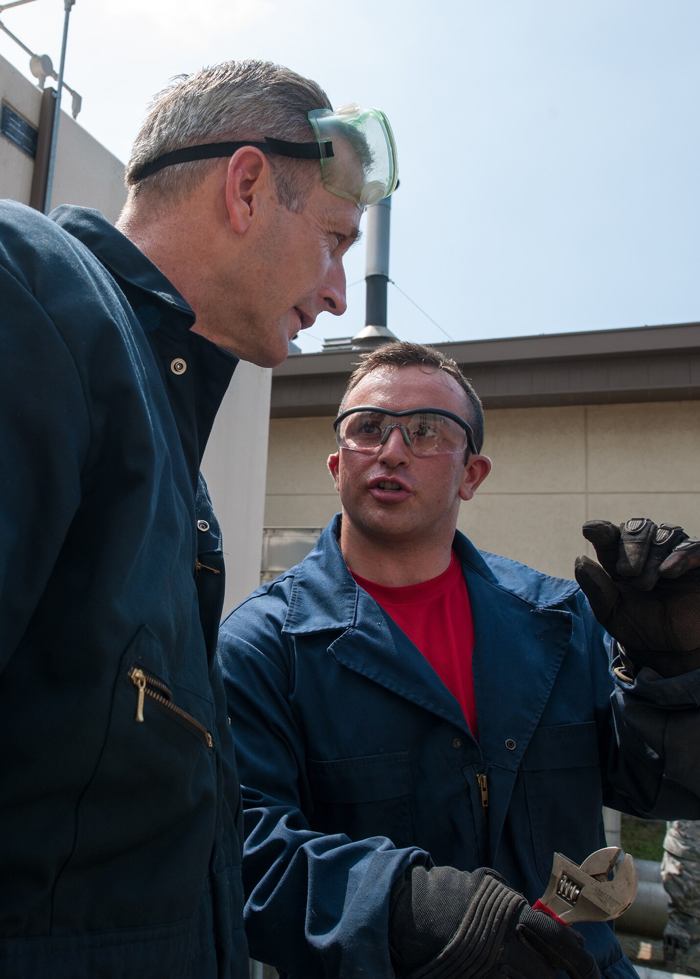 Senior Airman Matthew Long, 8th Civil Engineer Squadron heating, ventilation, air conditioning and refrigeration journeyman, explains how to solder an electronic expansion valve of a chiller to Lt. Gen. Terrence O'Shaughnessy, 7th Air Force and Air Component Command U.S. Forces Korea/U.S. Combined Forces commander, at Kunsan Air Base, Republic of Korea, July 31, 2015. During O’Shaughnessy’s two-day visit, he saw first-hand how the Wolf Pack contributes to deterring aggression on the peninsula. (U.S. Air Force photo by Senior Airman Katrina Heikkinen/Released)