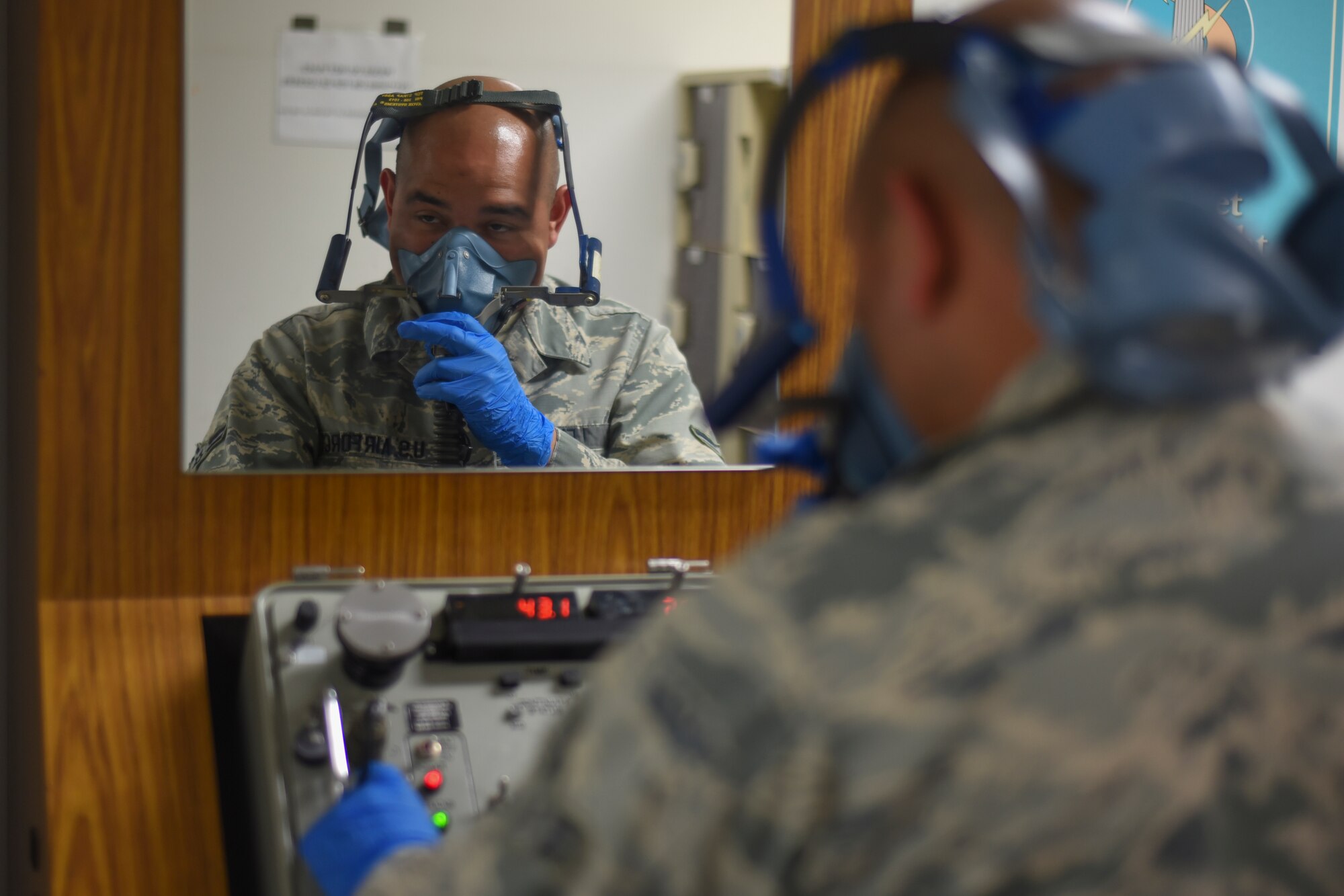 Airman 1st Class Raymundo Leija, 374th Operations Support Squadron aircrew flight equipment journeyman, checks a quick donning mask at a simulated 43,000 feet at Yokota Air Base, Japan, July 29, 2015. The quick donning masks, which are located in the cockpit, can be utilized by the aircrew so they can have a constant supply of oxygen if an in-flight incident occurs. (U.S. Air Force photo by Senior Airman Michael Washburn/Released)