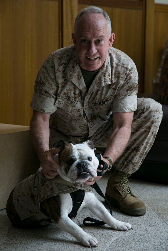 Rear Adm. Brent W. Scott, 19th chaplain of the Marine Corps, poses with Lance Cpl. Nelly, the canine mascot of 3rd Marine Logistics Group, III Marine Expeditionary Force, during a professional development training course May 19 at the Ocean Breeze Club, Camp Foster, Okinawa, Japan. The course is one of 12 hosted around the world, according to Scott, a Amarillo, Texas, native. It reinforces chaplains skills in suicide prevention, intervention and postvention. This is the first time Scott has visited Okinawa as chaplain of the Marine Corps. (U.S. Marine Corps photo by Cpl. Brittany A. James/Released)