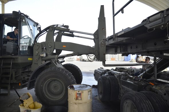 Staff Sgt. Jason and Senior Airman Jacob position an adverse terrain forklift vehicle underneath a 60,000-pound aircraft loader during maintenance at an undisclosed location in Southwest Asia, May 24, 2015. The forklift was used to relieve weight off of the lift cylinder. Jason is the NCO in charge of material handling equipment and Jacob is a MHE mechanic. Both are assigned to the expeditionary logistics readiness squadron. (U.S. Air Force photo/Tech. Sgt. Christopher Boitz)