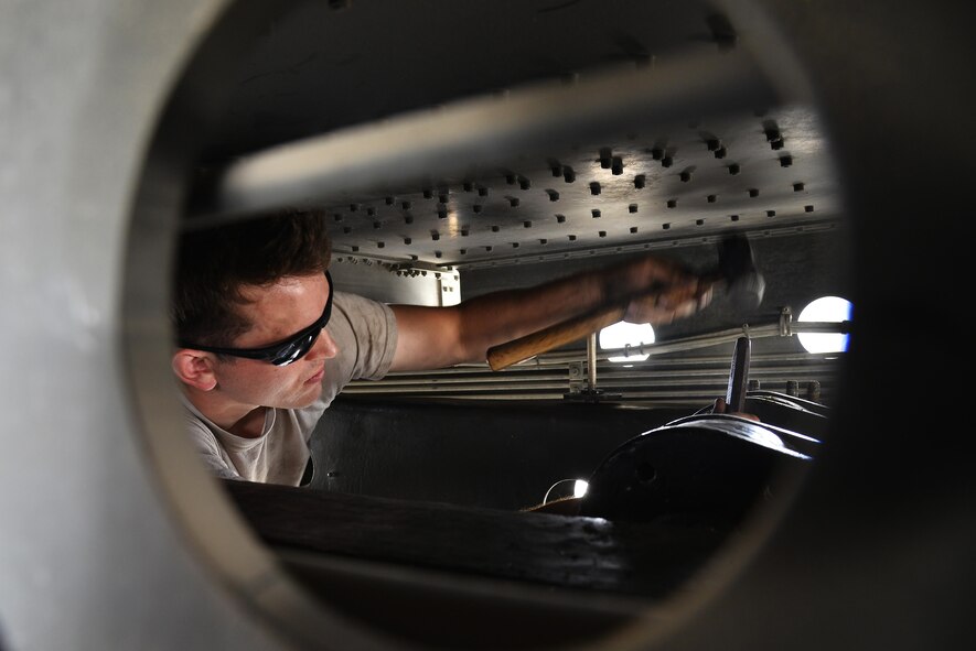 Senior Airman Jacob drives a holding pin in place on a lift cylinder on a 60,000-pound aircraft loader during maintenance at an undisclosed location in Southwest Asia, May 24, 2015. The holding pin keeps the lift cylinder in place and allows it to lower and raise the aircraft loader. Jacob is a material handling equipment mechanic assigned to the expeditionary logistics readiness squadron. (U.S. Air Force photo/Tech. Sgt. Christopher Boitz)