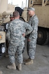 Chief Warrant Officer 2 John Bales (right), the maintenance officer for the 3rd Battalion, 116th Cavalry, 3rd Sustainment Brigade, 103rd Sustainment Command (Expeditionary), and a Joseph, Ore., native, talks with two of his mechanics at the maintenance bay for the 3-116th Cav. Reg. in December, 2010. Bales manages the maintenance for the battalion while it is stationed at Joint Base Balad, Iraq.