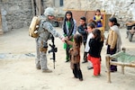 Army Sgt. Heather Eberle, combat medic with the Iowa National Guard's 734th Agribusiness Development Team, makes friends with Afghan children inside their home compound in Karula, a small town outside of Asadabad, the capital of Afghanistan's Kunar Province during a visit Jan. 13, 2011.