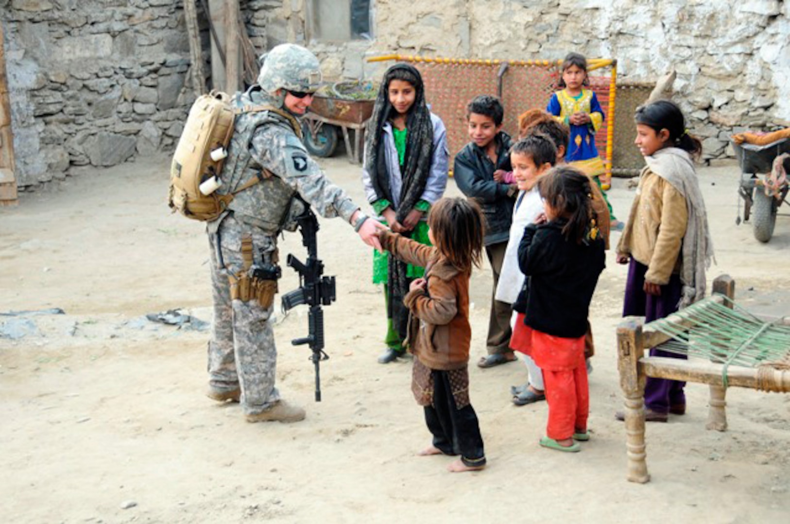 Army Sgt. Heather Eberle, combat medic with the Iowa National Guard's 734th Agribusiness Development Team, makes friends with Afghan children inside their home compound in Karula, a small town outside of Asadabad, the capital of Afghanistan's Kunar Province during a visit Jan. 13, 2011.