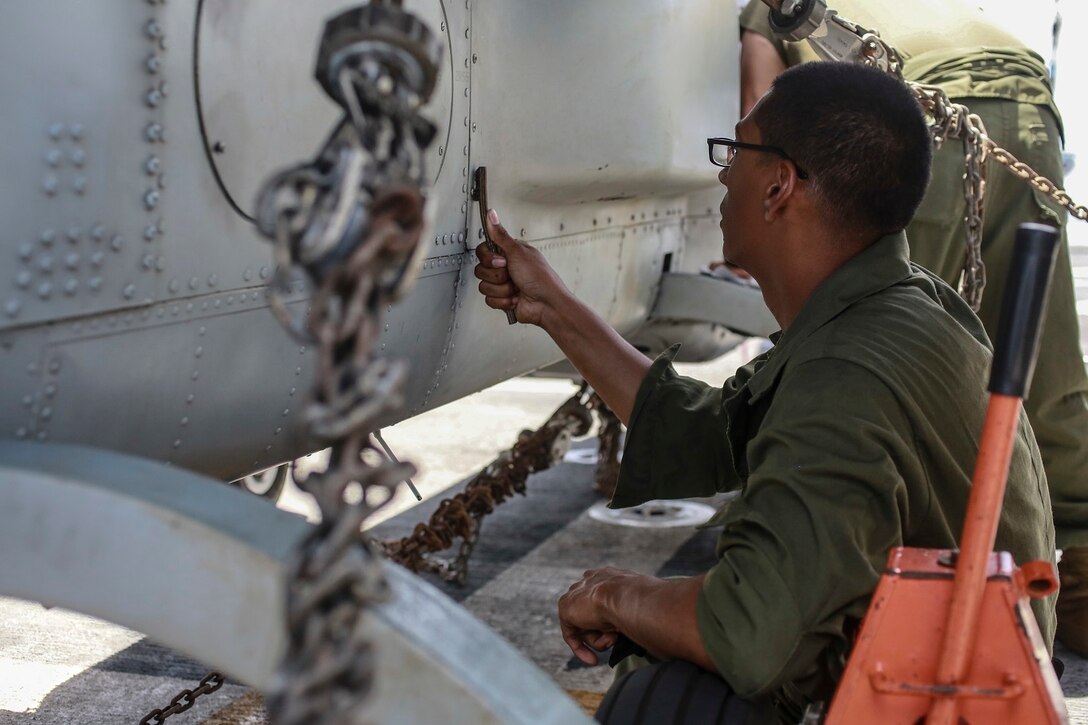 U.S. Marine Lance Cpl. Daniel Rosales conducts corrosion prevention and treatment on an AH-1Z Viper aboard the USS Anchorage (LPD 23) at sea in the Pacific Ocean, May 28, 2015. Rosales is a helicopter mechanic with Marine Medium Tiltrotor Squadron 161 (Reinforced), 15th Marine Expeditionary Unit. The Marines of the 15th MEU ensure their aircraft are ready to operate at all times. (U.S. Marine Corps photo by Cpl. Steve H. Lopez/Released)