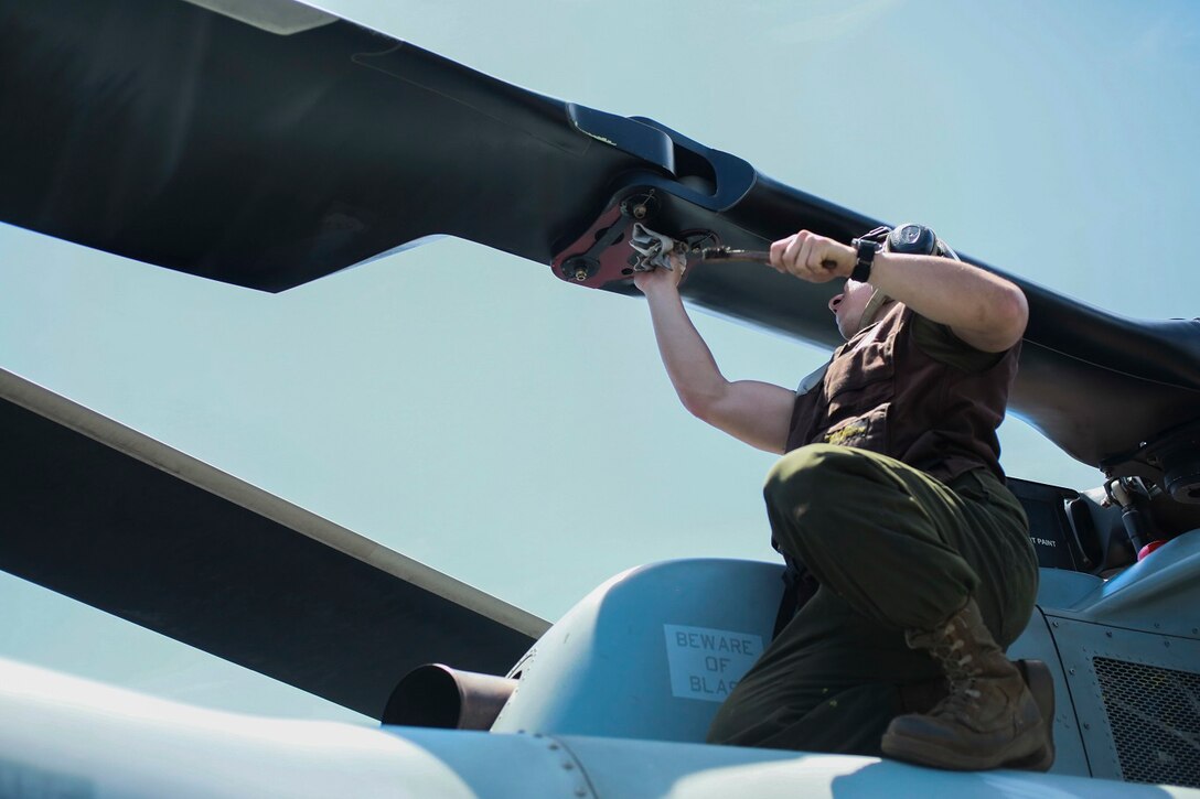 U.S. Marine Lance Cpl. Klein Johnson conducts corrosion prevention and treatment on an AH-1Z Viper aboard the USS Anchorage (LPD 23) at sea in the Pacific Ocean, May 28, 2015. Johnson is a helicopter mechanic with Marine Medium Tiltrotor Squadron 161 (Reinforced), 15th Marine Expeditionary Unit. The Marines of the 15th MEU ensure their aircraft are ready to operate at all times. (U.S. Marine Corps photo by Cpl. Steve H. Lopez/Released)