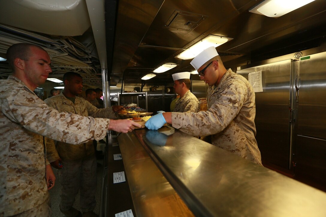 U.S. Marines serve each other meals on the mess deck of the USS Anchorage (LPD 23) at sea in the Pacific Ocean, May 24, 2015. The Marines and Sailors with the food service division take pride in the quality of service provided to the crew embarked aboard the Anchorage. (U.S. Marine Corps photo by Sgt. Jamean Berry/Released)
