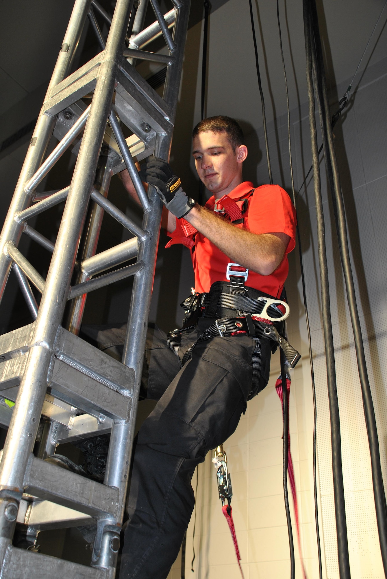 Staff Sgt. Brandon Armagost, a member of the Tops In Blue Technical Flight, climbs down after checking the stage rigging in the Joint Base San Antonio-Lackland Bob Hope Theater May 11. The 2015 TIB team hits the road next week to begin this year's tour. (U.S. Air Force photo/Debbie Aragon/Released)