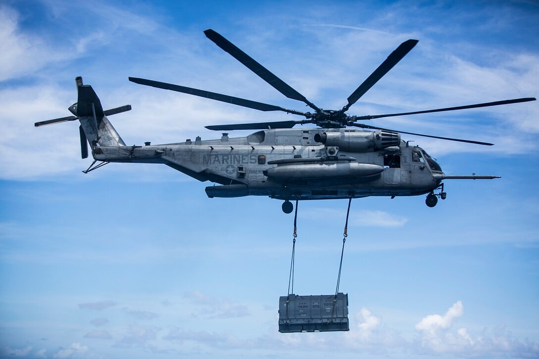 A CH-53E Super Stallion with Medium Marine Tiltrotor Squadron 161 (Reinforced), 15th Marine Expeditionary Unit, lifts an AV-8B Harrier engine off the flight deck of the USS Essex (LHD 2) at sea in the Pacific Ocean May 31, 2015. The engine was transported to the USNS Wally Schirra (T-AKE 8) during a replenishment at sea. (U.S. Marine Corps photo by Cpl. Anna Albrecht/Released)