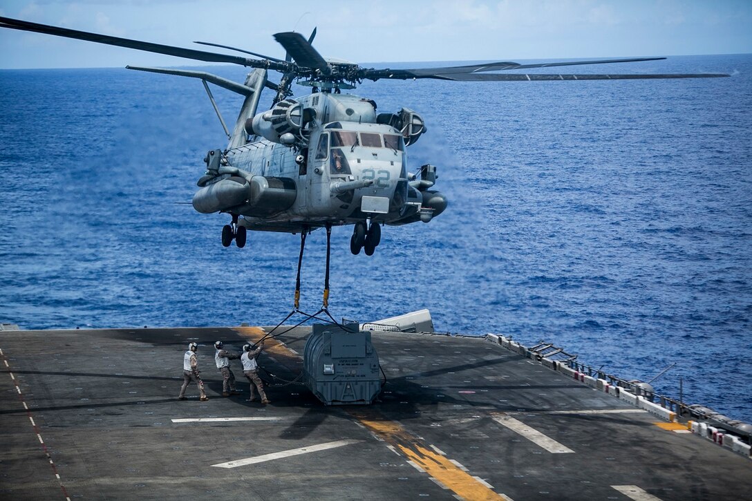 A CH-53E Super Stallion with Medium Marine Tiltrotor Squadron 161 (Reinforced), 15th Marine Expeditionary Unit, lifts an AV-8B Harrier engine off the flight deck of the USS Essex (LHD 2) at sea in the Pacific Ocean May 31, 2015. The engine was transported to the USNS Wally Schirra (T-AKE 8) during a replenishment at sea. (U.S. Marine Corps photo by Cpl. Anna Albrecht/Released)