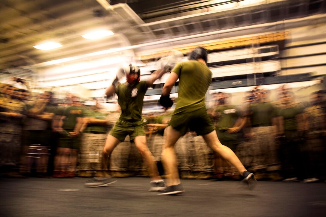 U.S. Marine Cpl. Roman Fernandez, left, and 1st Lt. Paul Hollwedel  duke it out in the hangar bay of the USS Essex (LHD 2) at sea in the Pacific Ocean, May 29, 2015. Fernandez is a team leader and Hollwedel is the executive officer with Lima Company, Battalion Landing Team 3rd Battalion, 1st Marine Regiment, 15th Marine Expeditionary Unit. The Marines find unique ways to continue to maintain combat readiness during their seven-month deployment through the Pacific and Central Command areas. (U.S. Marine Corps photo by Cpl. Elize McKelvey/released)