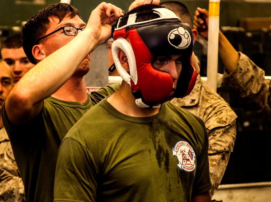 U.S. Marine Cpl. Roman Fernandez gets his gear adjusted between matches in the hangar bay of the USS Essex (LHD 2) at sea in the Pacific Ocean, May 29, 2015. Fernandez is a team leader with Lima Company, Battalion Landing Team 3rd Battalion, 1st Marine Regiment, 15th Marine Expeditionary Unit. The Marines find unique ways to continue to maintain combat readiness during their seven-month deployment through the Pacific and Central Command areas. (U.S. Marine Corps photo by Cpl. Elize McKelvey/released)