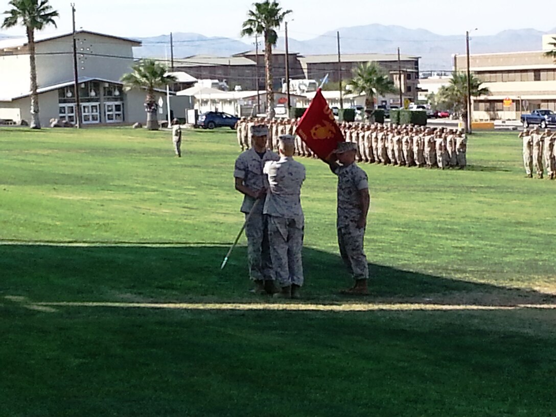 GySgt Antonio N. Soto (B Co 1stSgt) saluting while the passing of the guidon from outgoing commander (Capt Duane M. Gross) to incoming commander (Maj Thomas J. Heller).  In the background, over 600 Marines stand in formation, saluting, while change of command takes place.